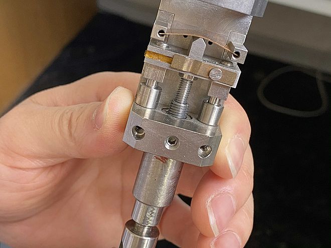 Durch Druck von unten verbiegt sich das Bauelement. Dadurch verlängert sich die eingebettete Graphenschicht, und ihre elektrischen Eigenschaften ändern sich. (Foto: Universität Basel/SNI)