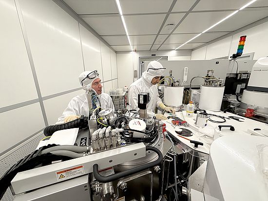 Zwei Personen an einer Sputteranlage